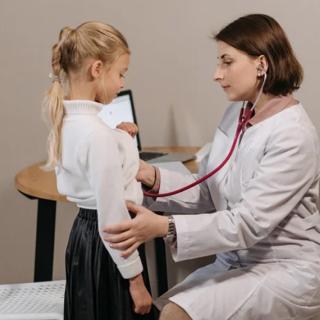 image of female physician using a stethoscope on a young female patient