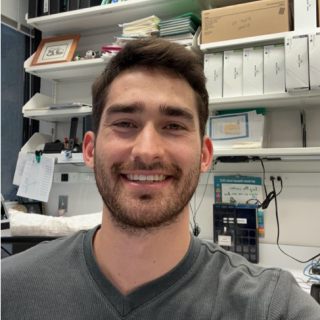 Man in grey t shirt in front of desk in lab