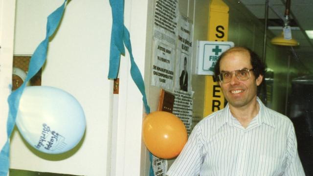 Howard A. Young, Ph.D., cutting the ribbon to celebrate the opening of his lab in the 1980s.