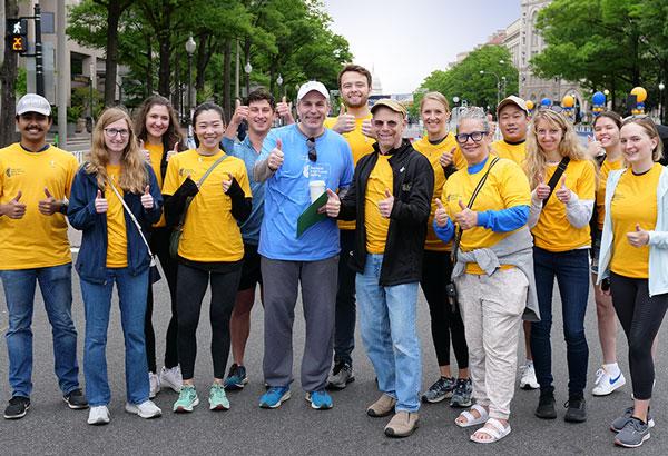 Group photo of people smiling outside with Dr. Gilbert in the center