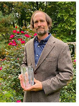 Photo of Eric Freed holding award from The Ohio State University Center for Retrovirus Research