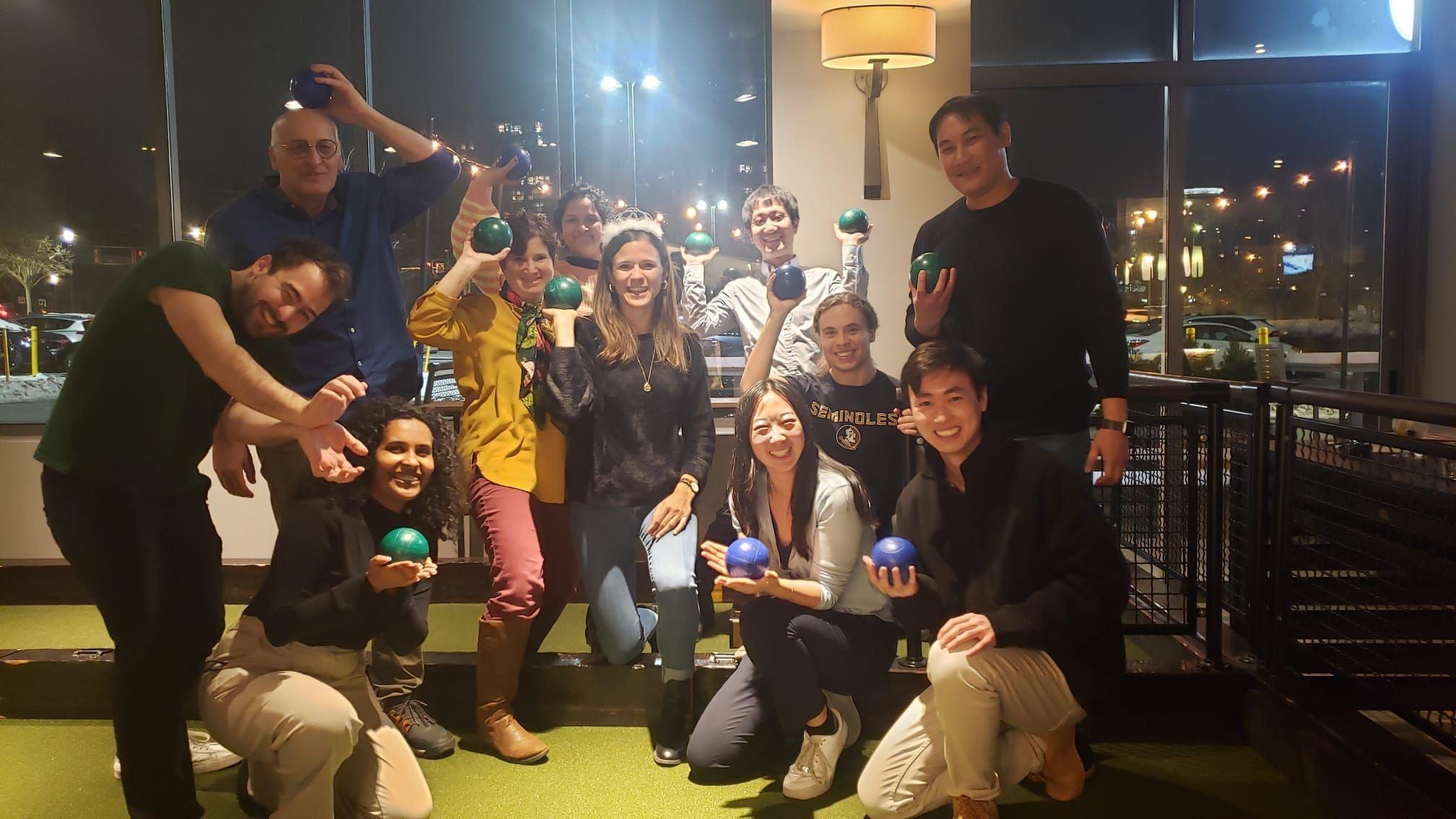 The group stands together with bowling balls in their hands