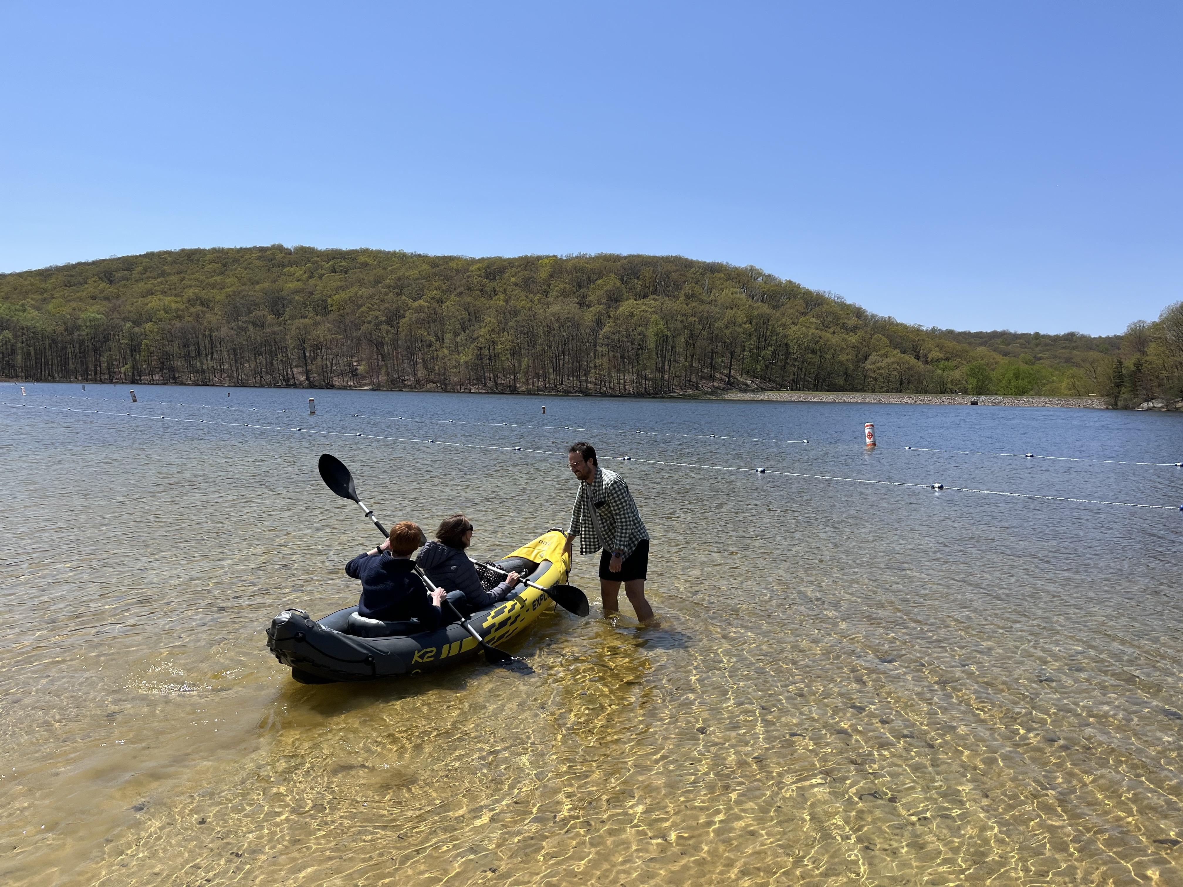 People getting out on a kayak on a lake