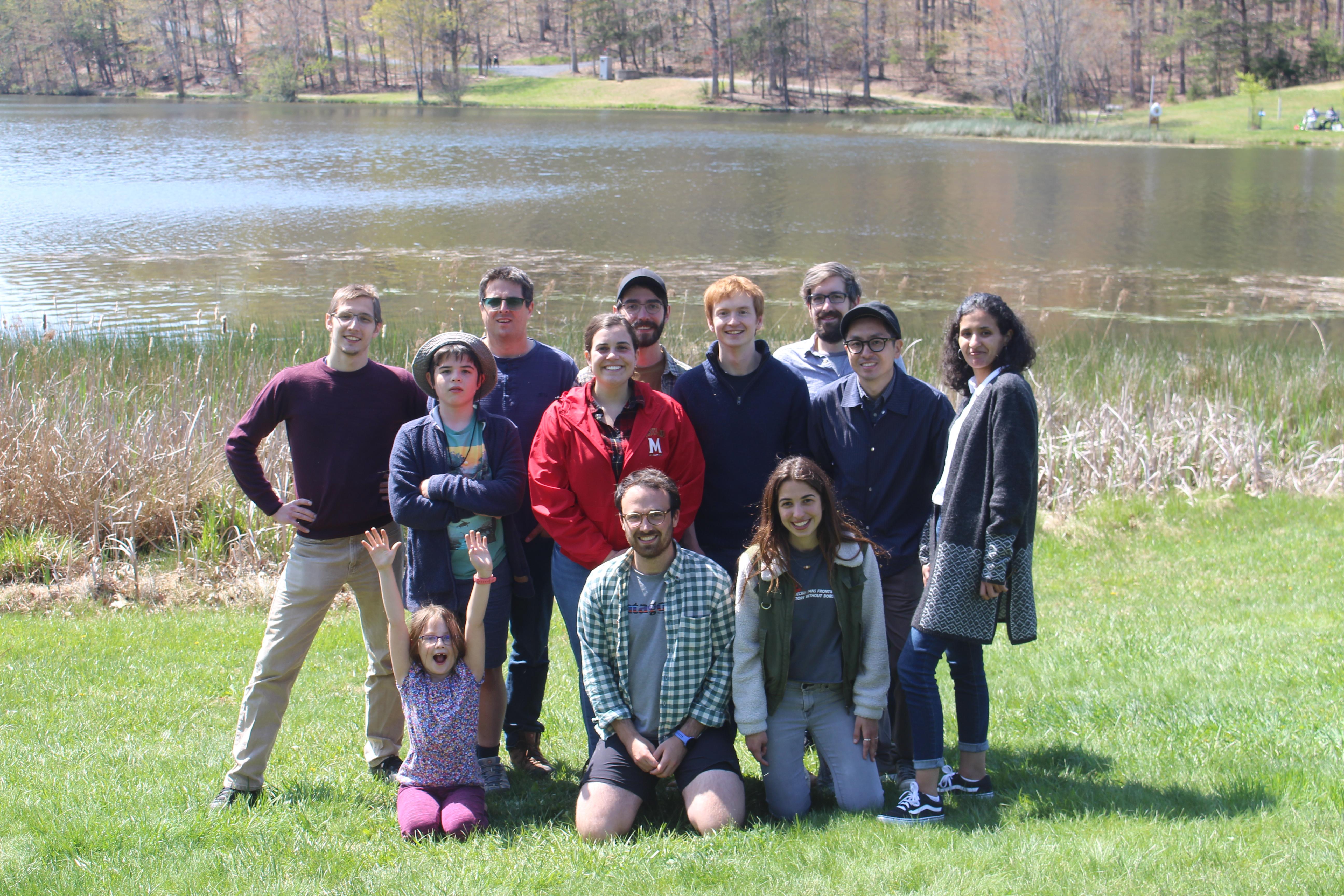 Group people standing next to a lake.