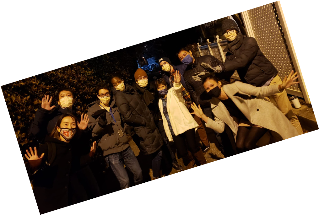 Members of the Taylor lab are gathered together for a group photo outside of a lab member’s home in the evening.